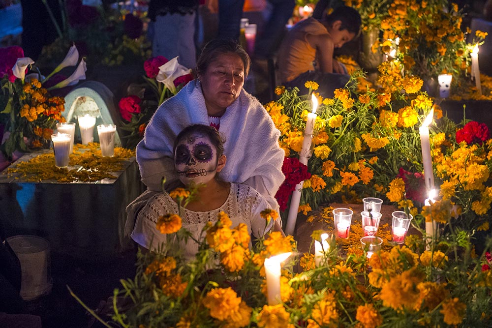 La gente visita el cementerio durante los festejos del Día de los muertos en México.